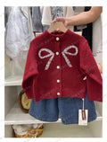 Girls cream cable knit cardigan with patch pockets and ruffled neckline